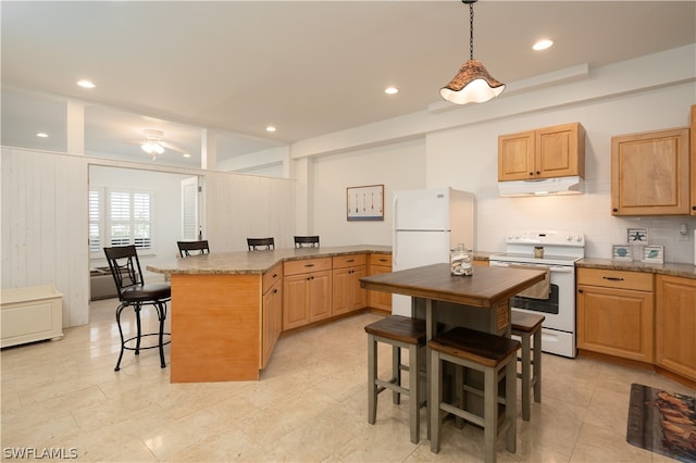 kitchen featuring a kitchen island, pendant lighting, a kitchen bar, light stone counters, and white appliances