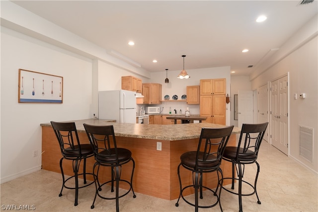 kitchen with light brown cabinetry, a breakfast bar, hanging light fixtures, kitchen peninsula, and white appliances