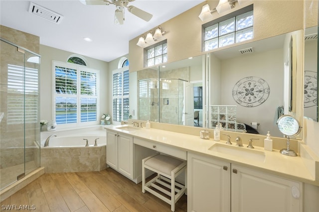 bathroom featuring hardwood / wood-style flooring, ceiling fan, vanity, and plus walk in shower