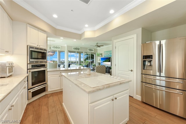 kitchen with backsplash, a center island, white cabinets, and stainless steel appliances