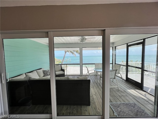 interior space with a water view and ceiling fan