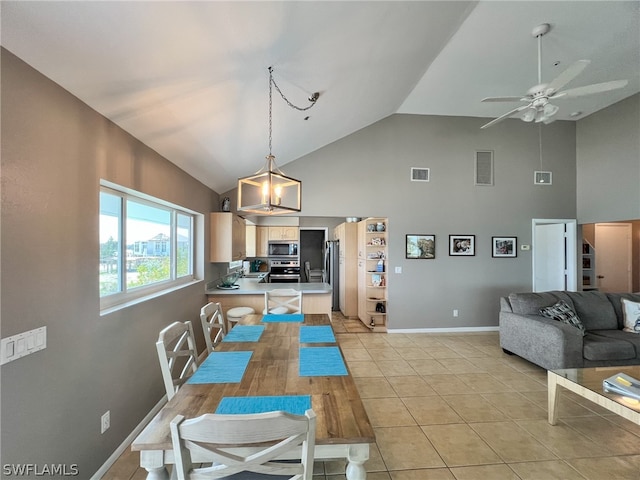 dining area featuring light tile floors, high vaulted ceiling, and ceiling fan with notable chandelier