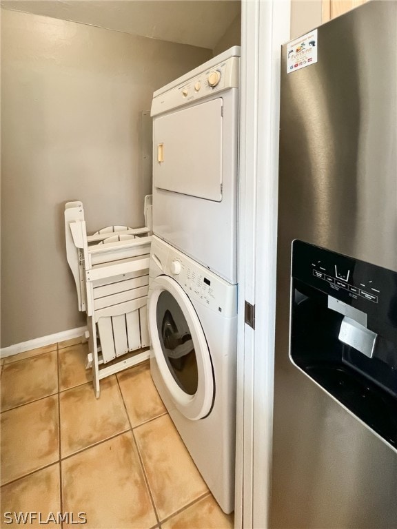 washroom featuring stacked washer and clothes dryer and light tile flooring