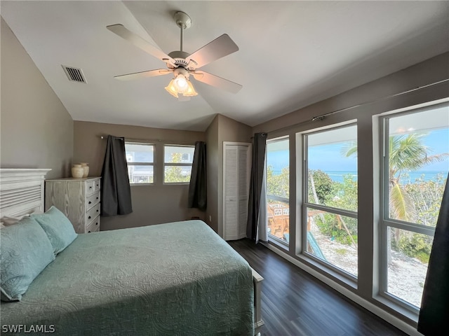 bedroom with a closet, lofted ceiling, dark wood-type flooring, ceiling fan, and access to outside