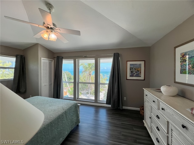 bedroom featuring a closet, ceiling fan, dark wood-type flooring, and vaulted ceiling