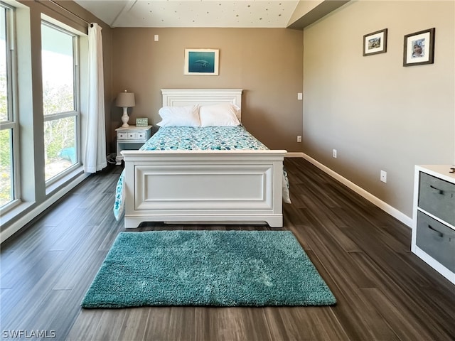 bedroom with dark hardwood / wood-style floors and vaulted ceiling