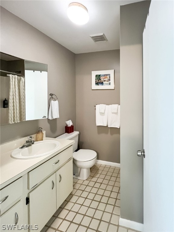 bathroom with toilet, tile floors, and vanity