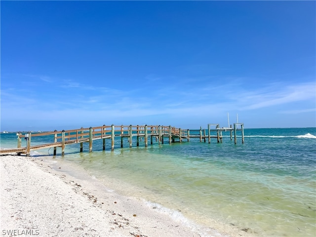 dock area with a beach view and a water view