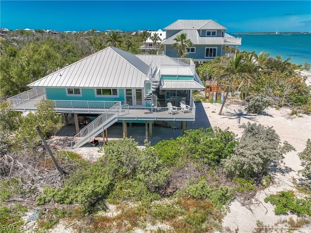 back of property with a balcony and a water view