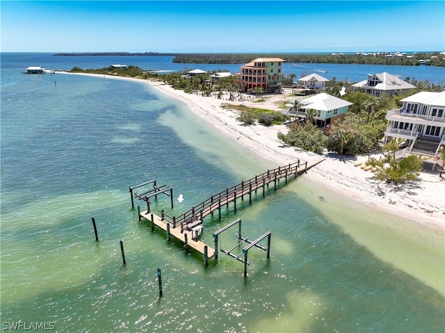 birds eye view of property with a water view and a beach view