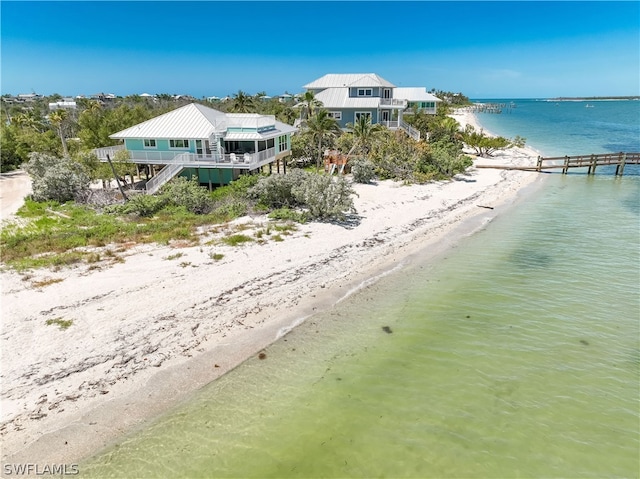 birds eye view of property featuring a beach view and a water view