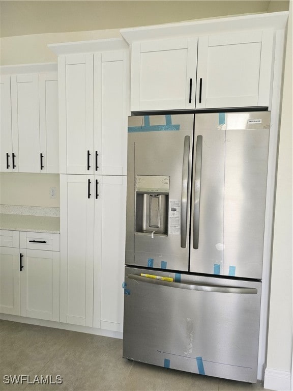 kitchen with stainless steel fridge with ice dispenser and white cabinetry