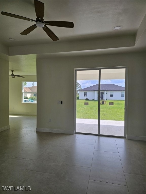 empty room featuring ceiling fan and tile patterned flooring