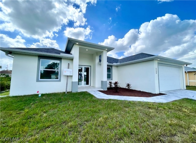 back of property with a garage, a yard, and french doors