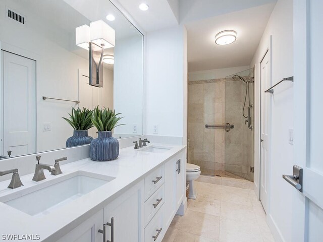 bathroom featuring tile patterned floors, vanity, toilet, and walk in shower