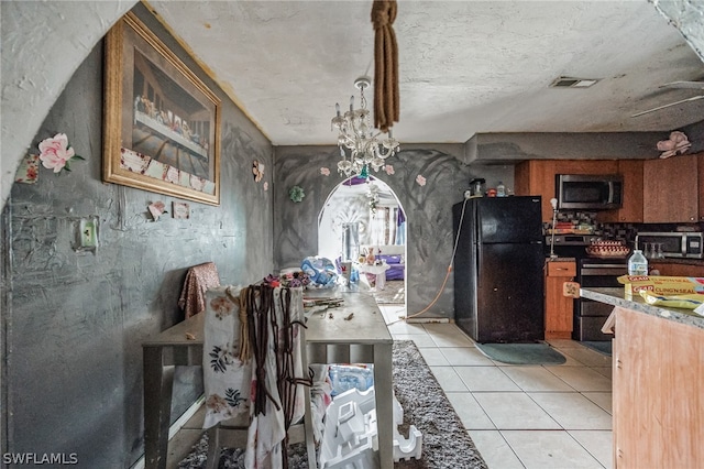 kitchen featuring stainless steel appliances and light tile flooring