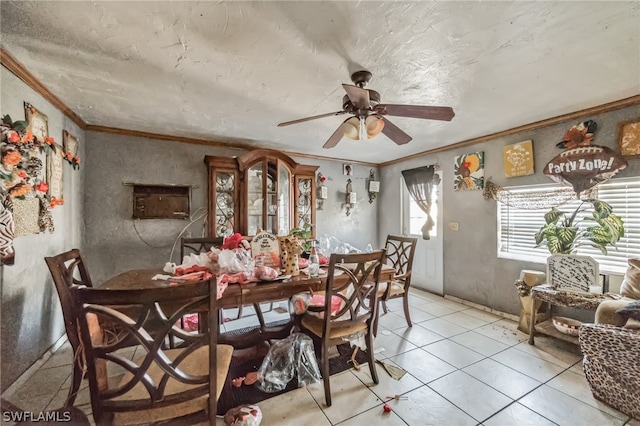 tiled dining room with ornamental molding and ceiling fan