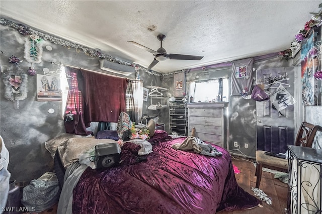 bedroom with a textured ceiling, ceiling fan, and dark hardwood / wood-style flooring