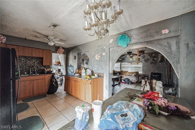 kitchen with ceiling fan, sink, light tile floors, a textured ceiling, and black fridge