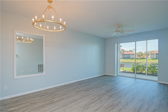 unfurnished room with ceiling fan with notable chandelier and light wood-type flooring