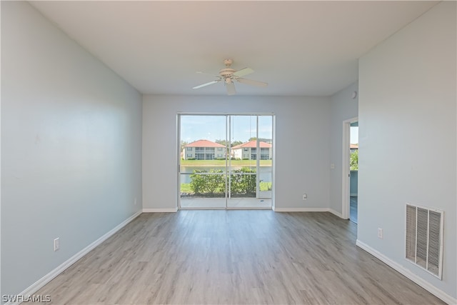 empty room with light wood-type flooring, ceiling fan, and a wealth of natural light