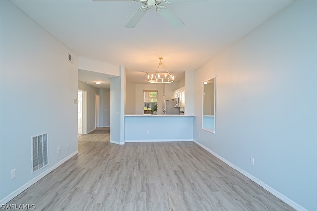 unfurnished living room featuring light hardwood / wood-style floors and ceiling fan with notable chandelier