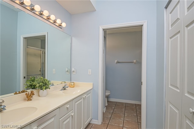 bathroom with double sink vanity, toilet, and tile flooring