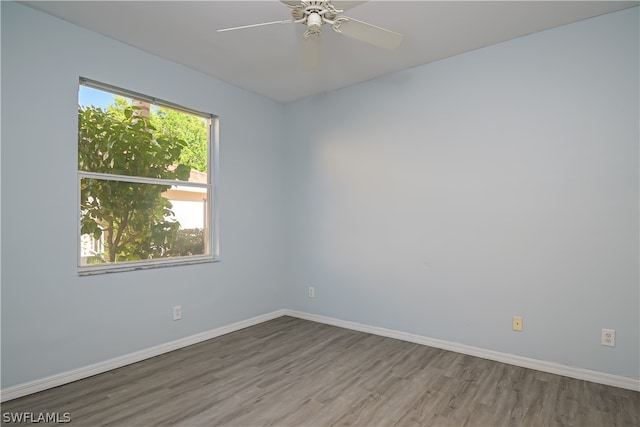 unfurnished room with dark hardwood / wood-style flooring, a healthy amount of sunlight, and ceiling fan