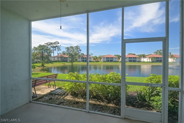 unfurnished sunroom featuring a water view