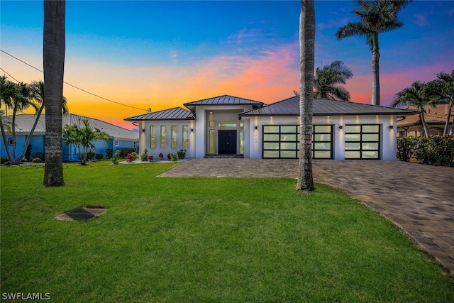 view of front of home with a garage and a yard