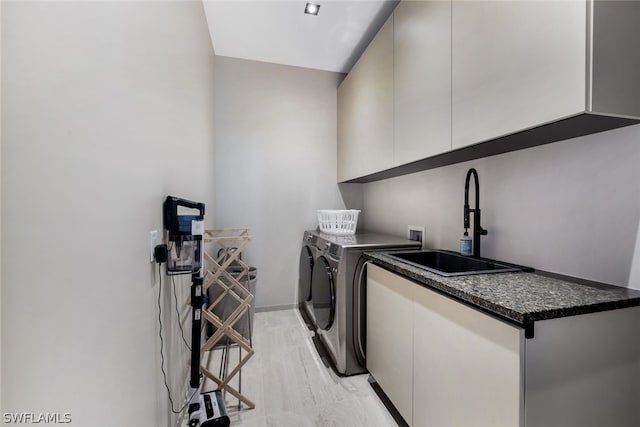 laundry room with cabinets, light hardwood / wood-style floors, sink, hookup for a washing machine, and independent washer and dryer