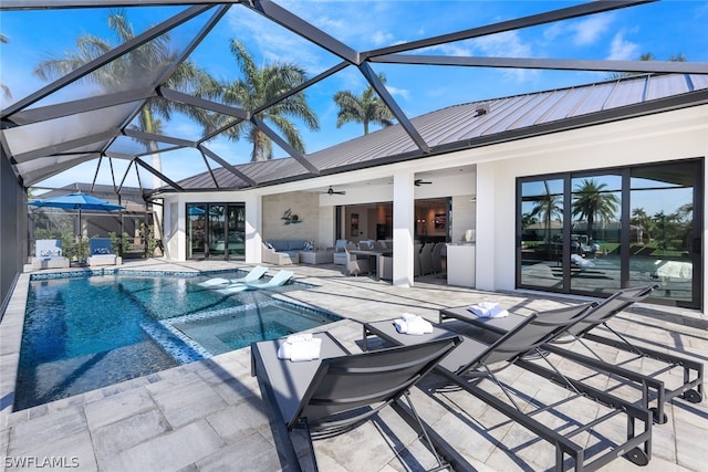 view of pool featuring glass enclosure, ceiling fan, and a patio area