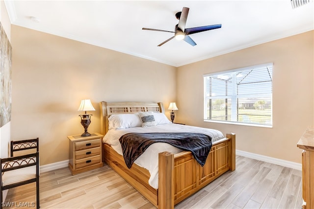 bedroom with light hardwood / wood-style flooring, crown molding, and ceiling fan