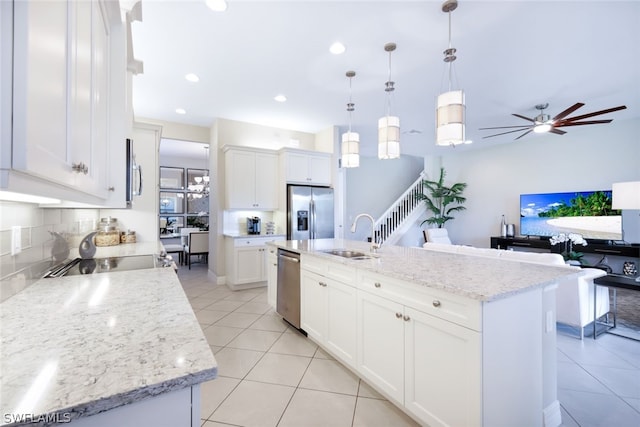 kitchen featuring sink, an island with sink, white cabinetry, and stainless steel appliances