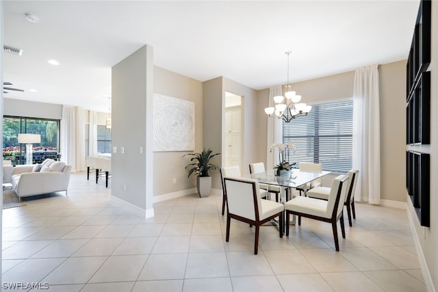 tiled dining room with a chandelier