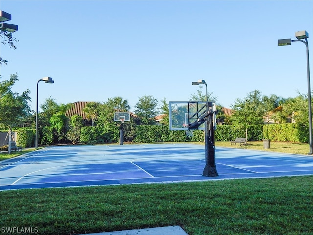 view of basketball court with a yard