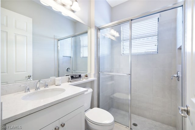 bathroom featuring walk in shower, oversized vanity, and toilet