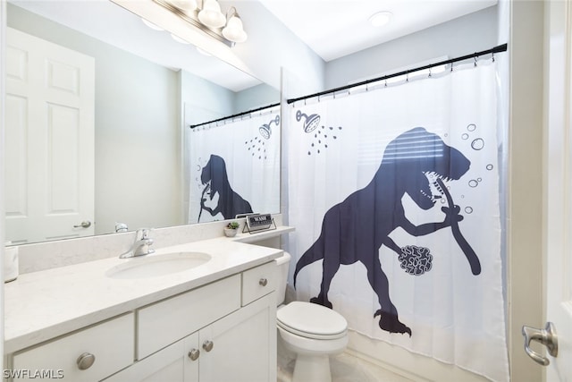 bathroom featuring toilet, vanity with extensive cabinet space, and tile flooring