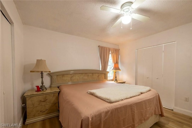 bedroom with hardwood / wood-style flooring, ceiling fan, and a textured ceiling