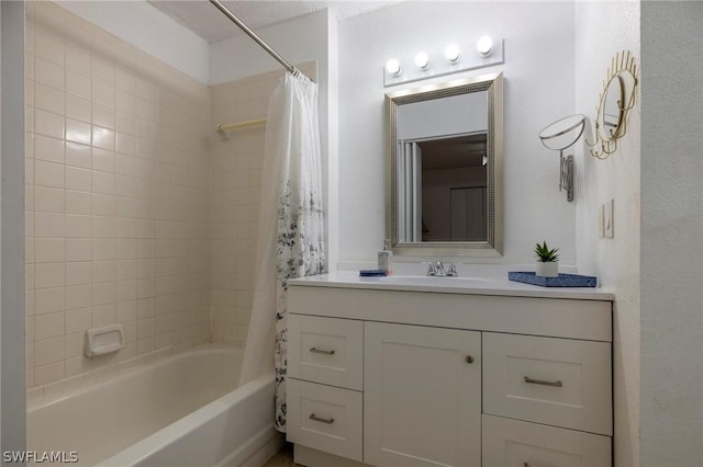 bathroom featuring a textured ceiling, vanity, and shower / bath combo with shower curtain