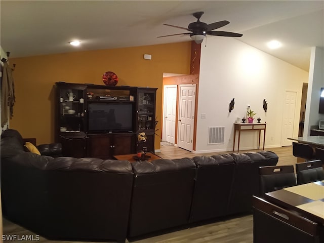 living room with lofted ceiling, ceiling fan, and light hardwood / wood-style flooring