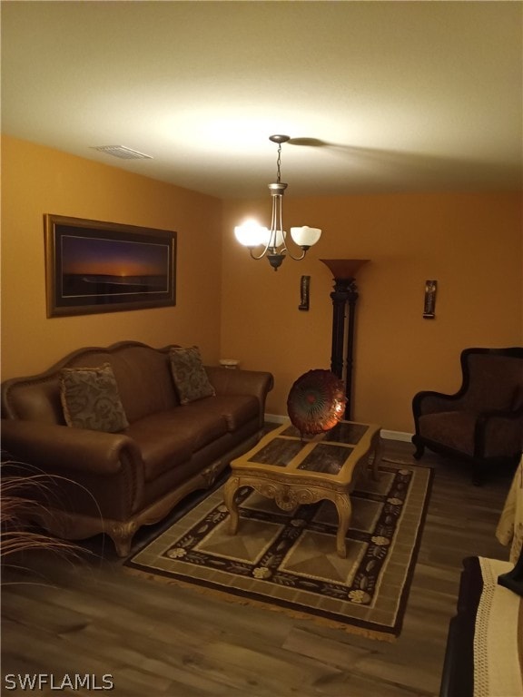 living room featuring a chandelier and dark hardwood / wood-style floors