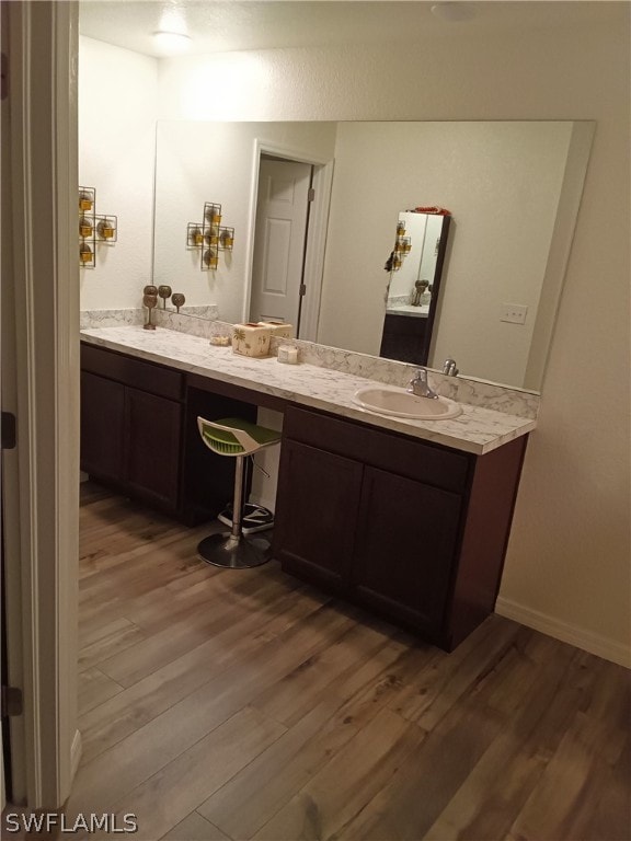 bathroom featuring hardwood / wood-style floors, dual sinks, and vanity with extensive cabinet space