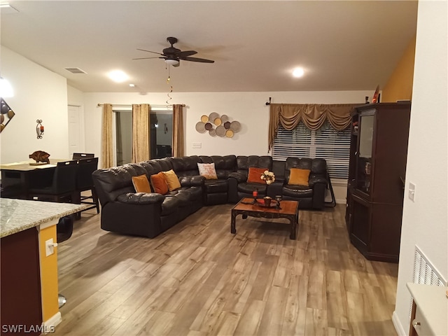 living room featuring hardwood / wood-style floors and ceiling fan