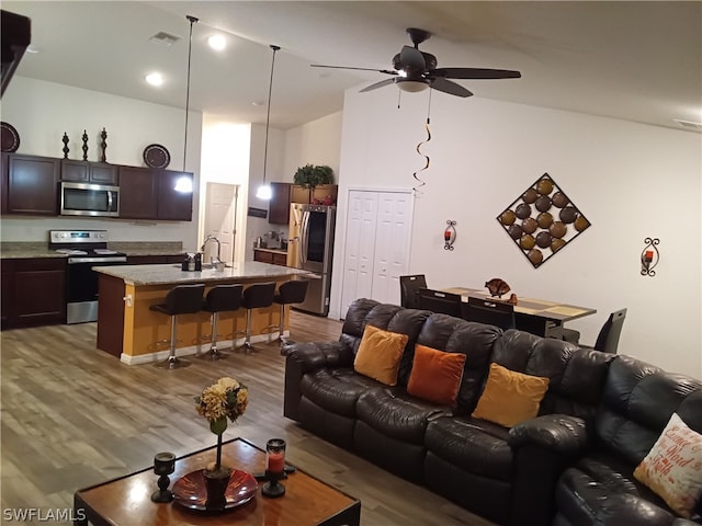 living room featuring sink, ceiling fan, and hardwood / wood-style flooring