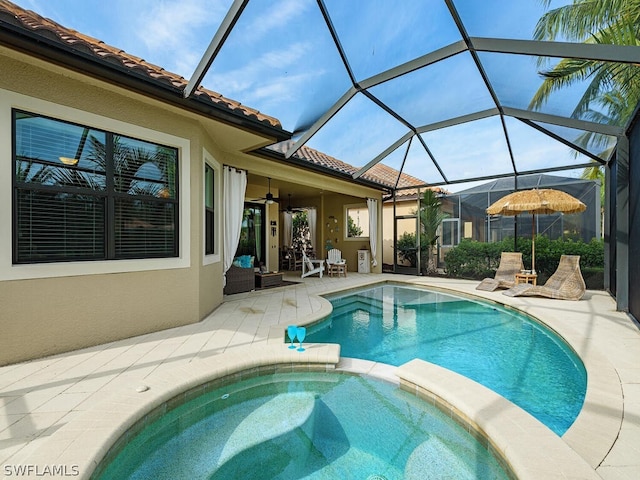 view of pool featuring a lanai, ceiling fan, a patio area, and an in ground hot tub