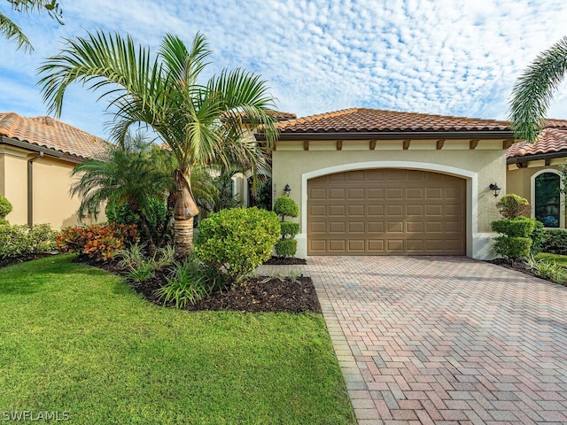 mediterranean / spanish house featuring a garage and a front lawn