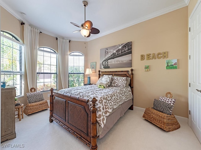 carpeted bedroom featuring ceiling fan and crown molding