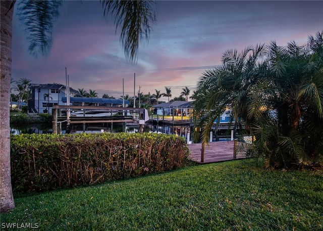 dock area featuring a lawn and a water view