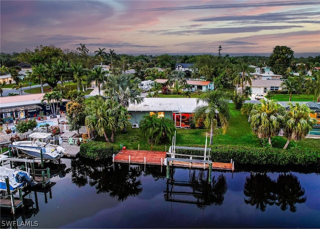 aerial view at dusk featuring a water view